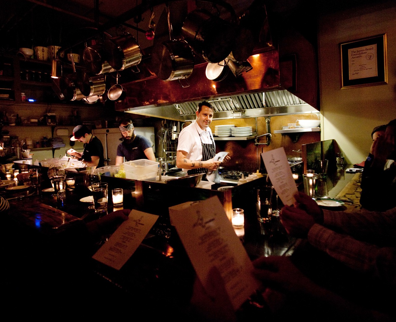 a chef stands in a small open kitchen