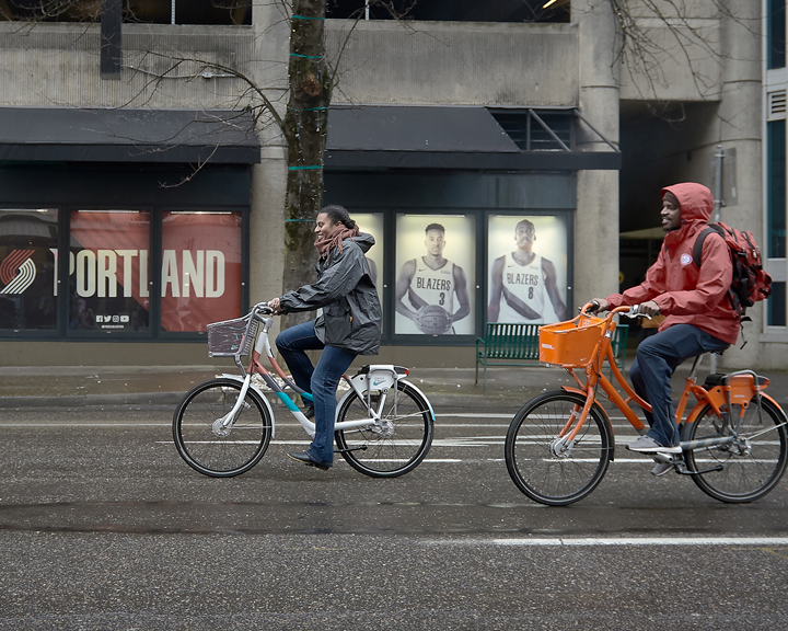 Cyclists bike through downtown Portland on bikes designed for Biketown Culture Collection