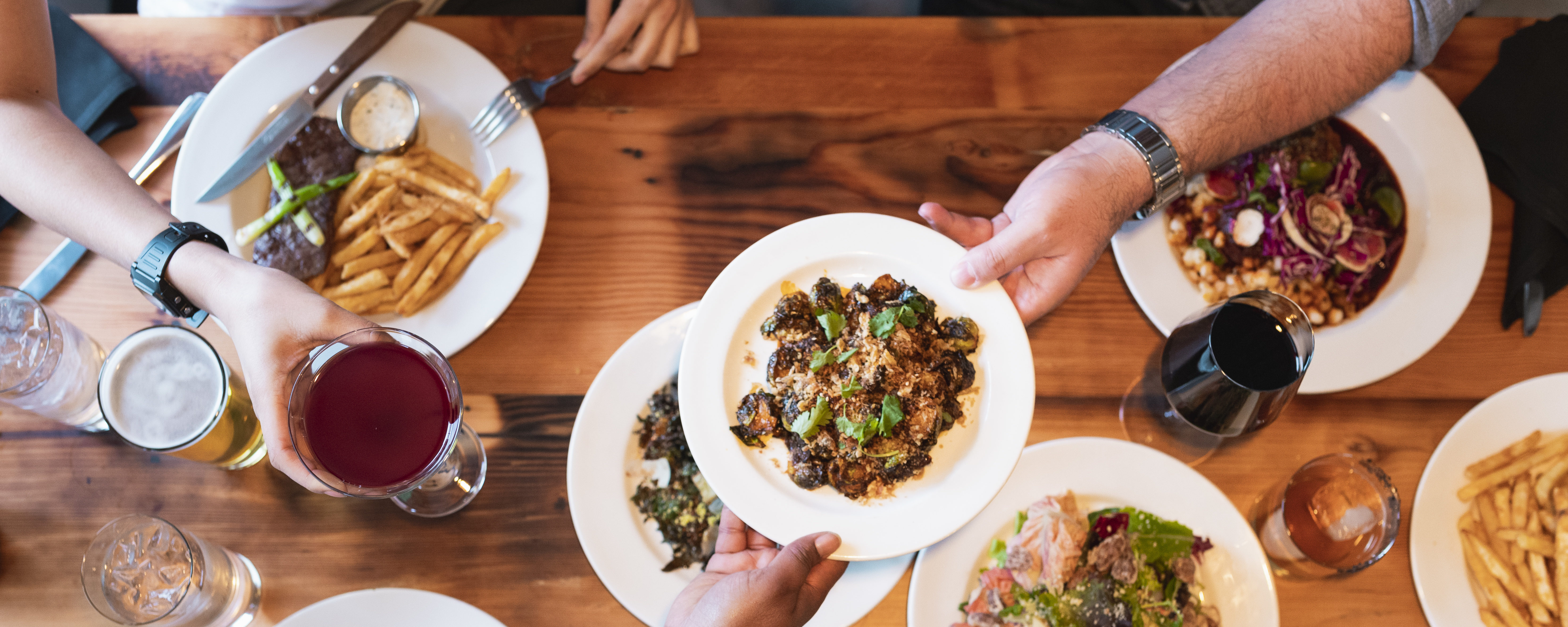 plates of food being shared on a wooden table