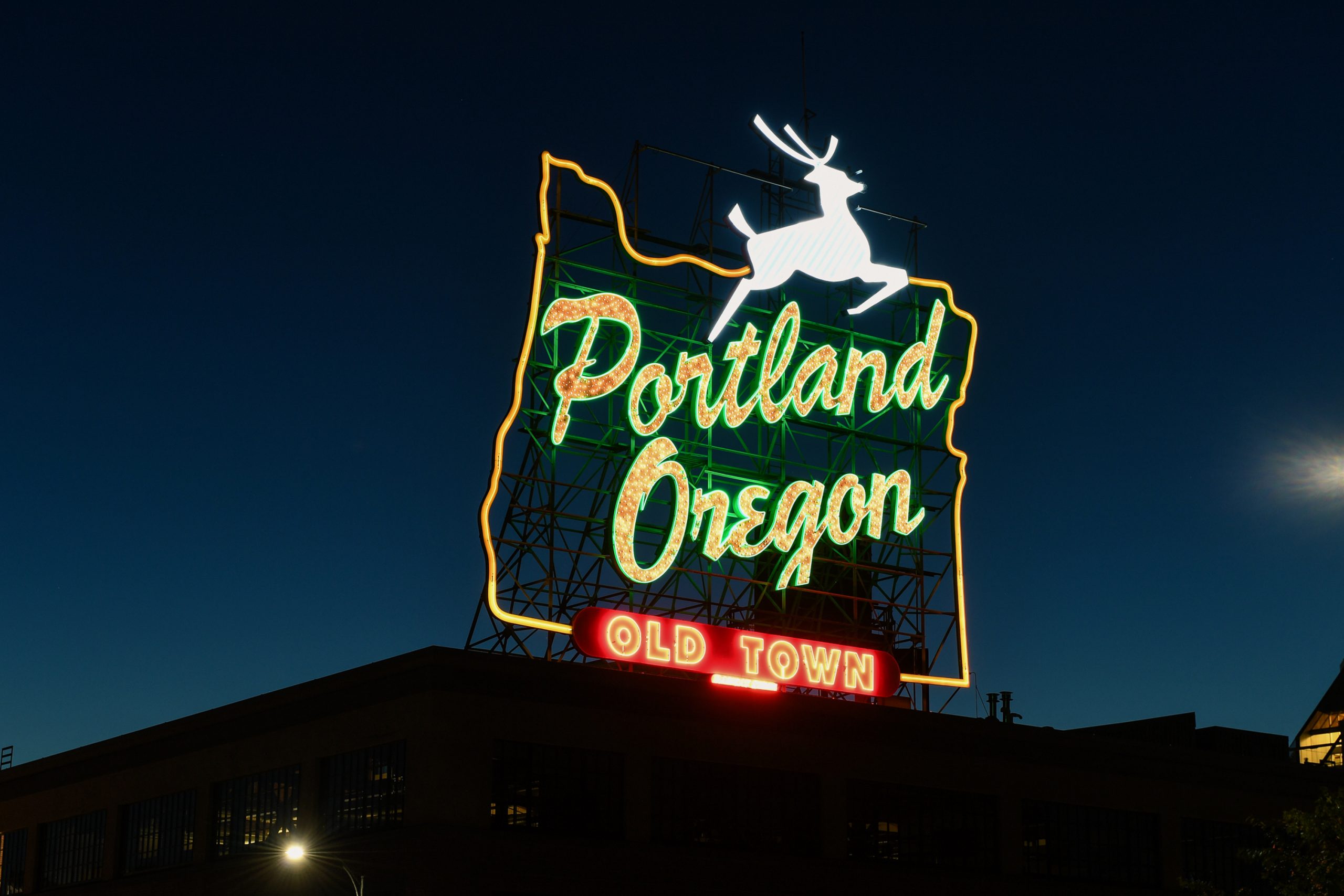 portland oregon old town neon sign with white stag in twilight sky