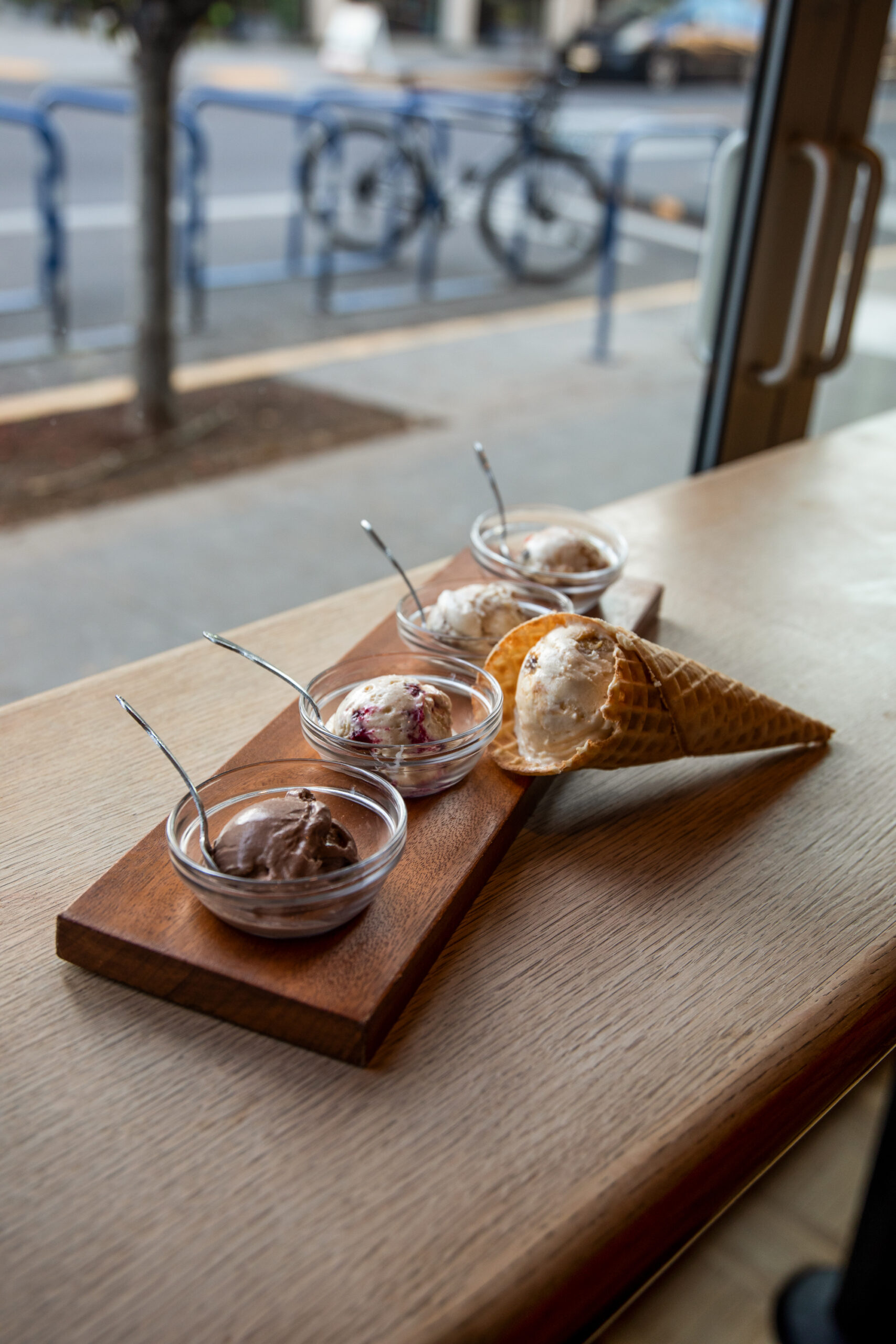 an ice cream sampler consisting of four small bowls and one sugar cone