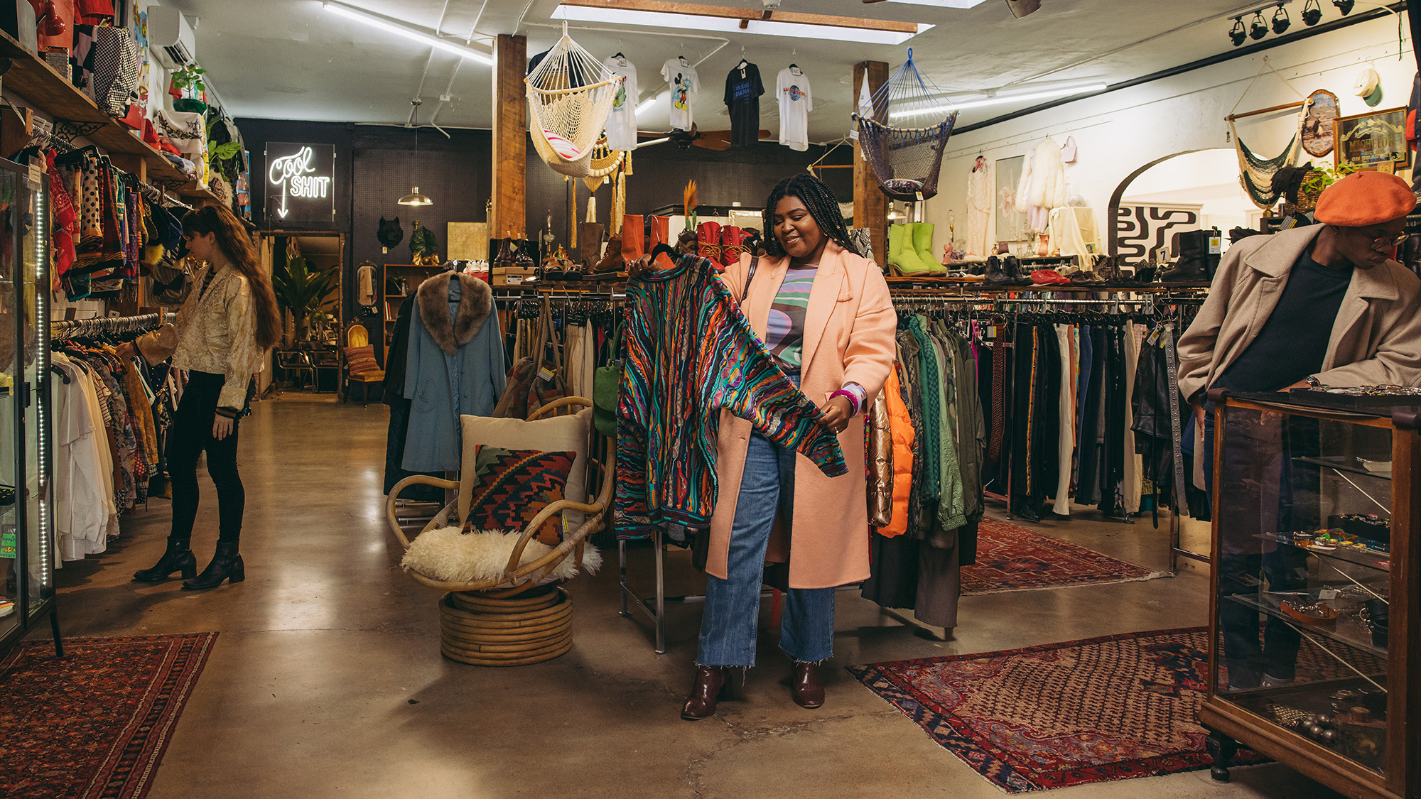 a woman looks at a sweater at Artifact PDX