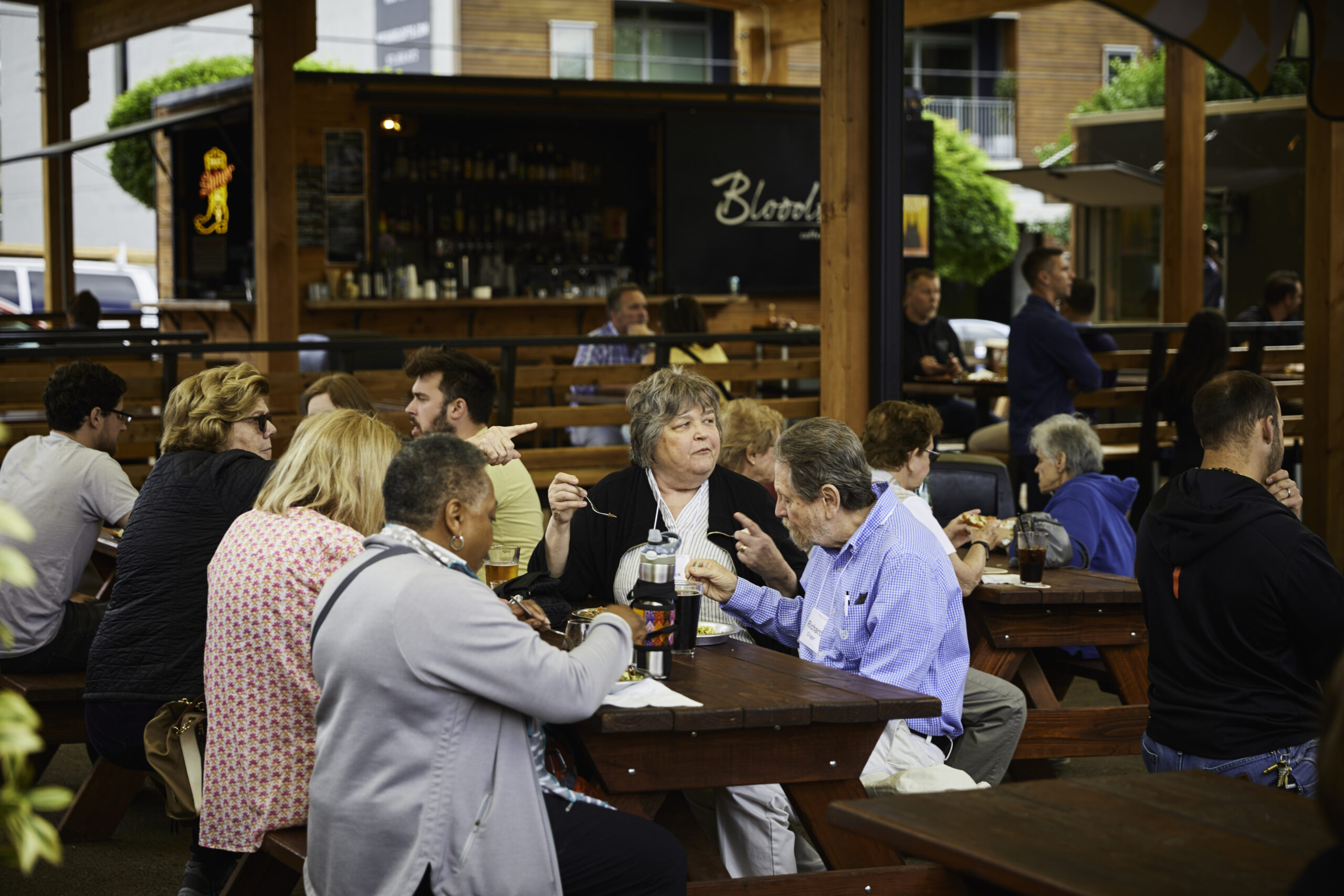 people eating at picnic tables in busy food cart pod
