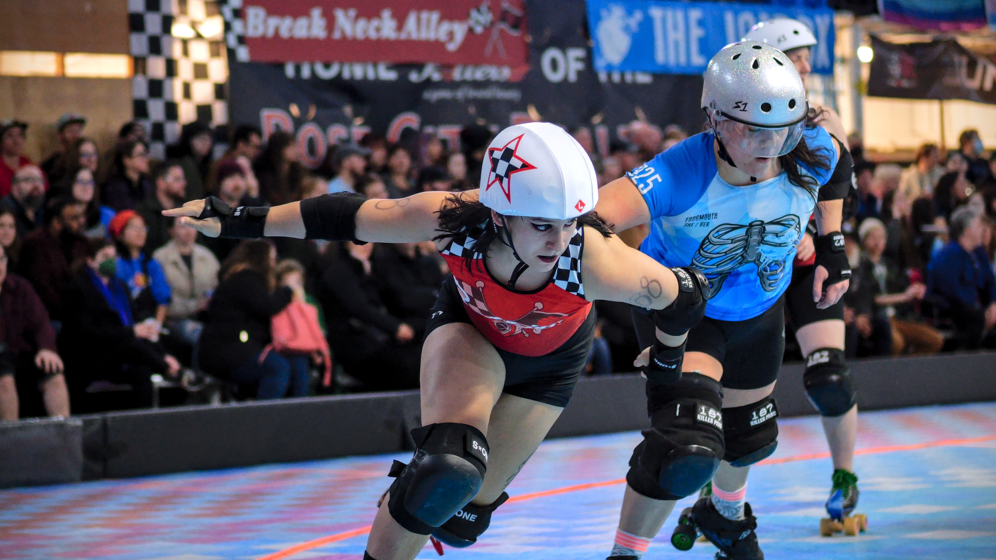 a roller derby skater with a star on their helmet passes another skater