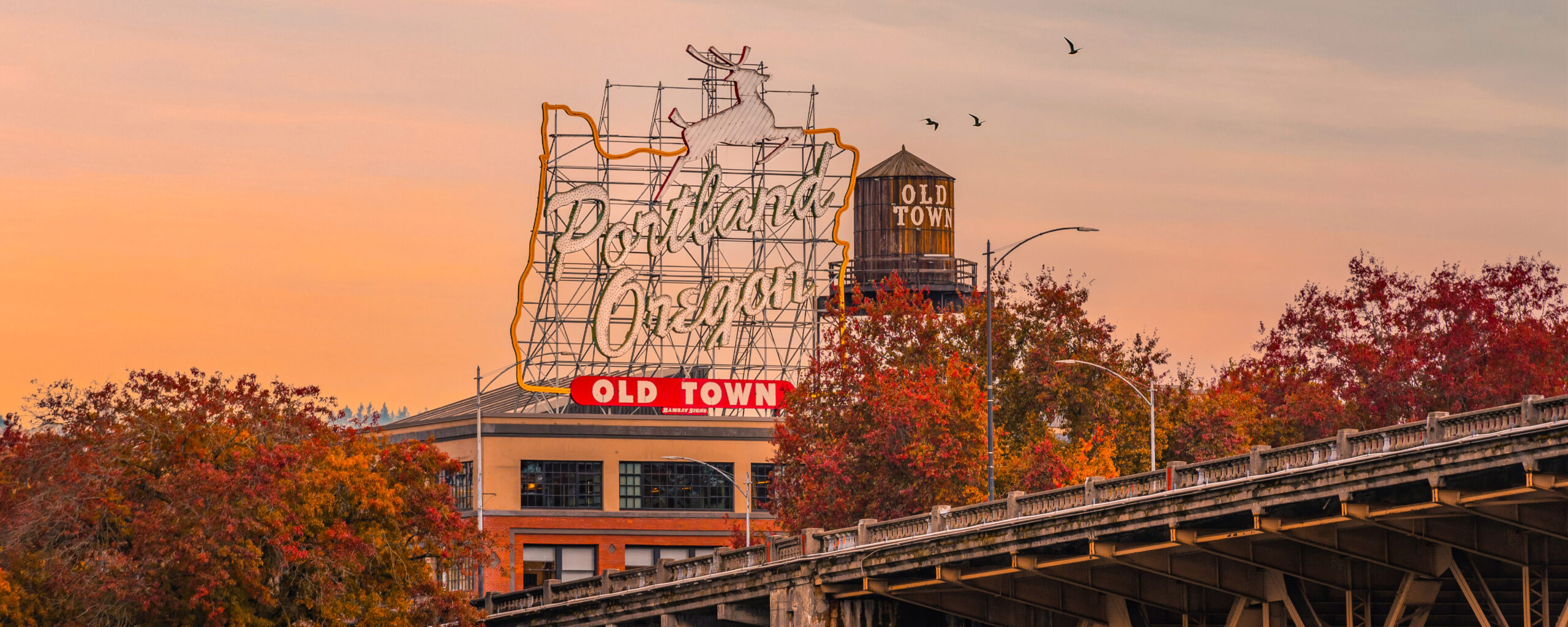 a sign reading portland, oregon against a fall sky