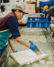 An Ota Tofu employee hand-cuts tofu into blocks.