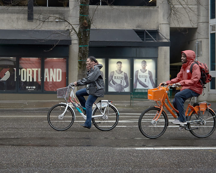 Cyclists bike through downtown Portland on bikes designed for Biketown Culture Collection
