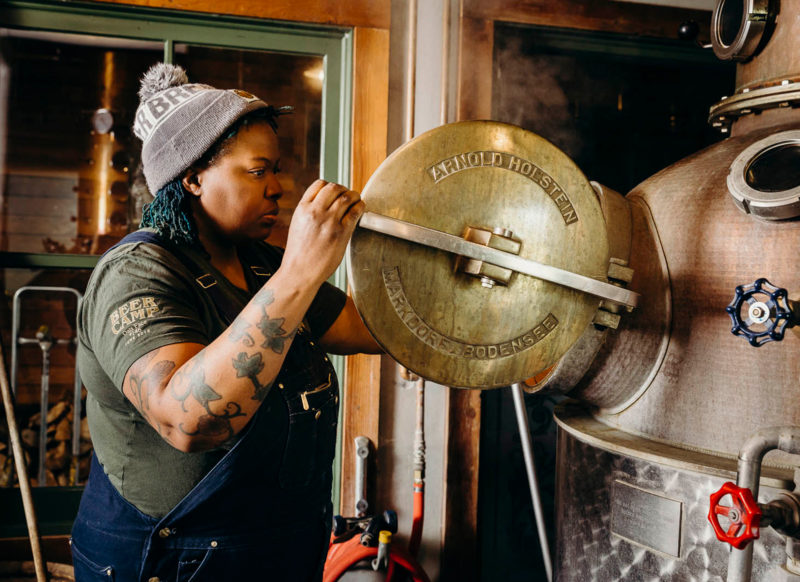 a person opens an alcohol distillation tank