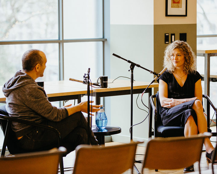 two people having a conversation while being recorded for a podcast
